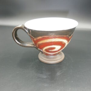 Ceramic art cup, with a unique design and the colours of Cream / white / red / beige 